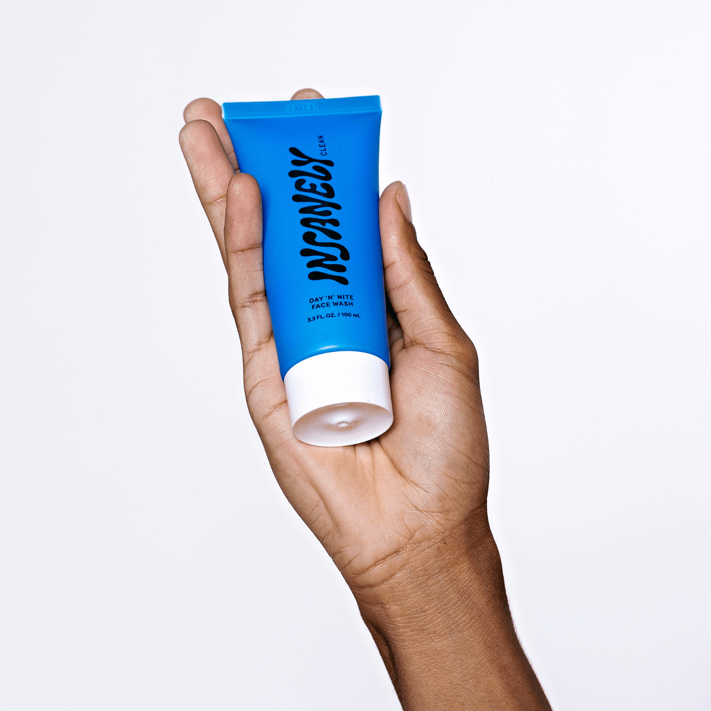 A hand displaying the best men's skincare product that is suitable for all skin types and is beard friendly.