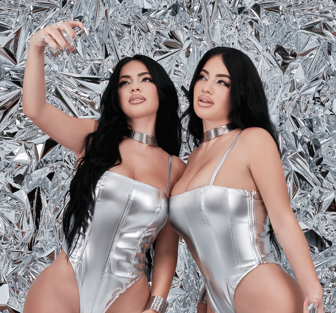 Celebrities twins, Brittany and Briana Murillo, posing with their best-selling perfume.