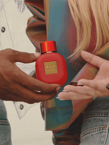 A man handing female celebrity, Hayley Kiyoko, her best-smelling perfume.