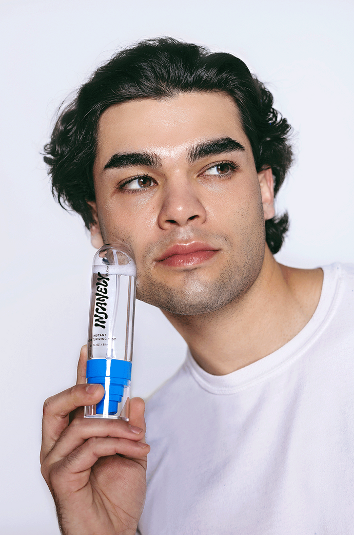 A man holding the best moisturizing mist against his face.
