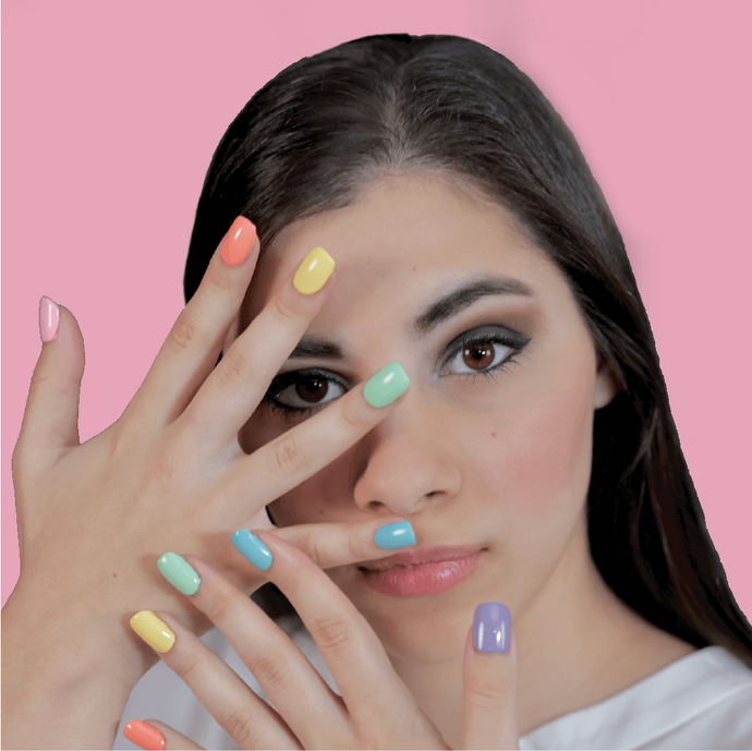 Female influencer, Moriah Elizabeth, holding her hands in front of her face with her nails painted in six different colors of the best, salon-quality nail polish.