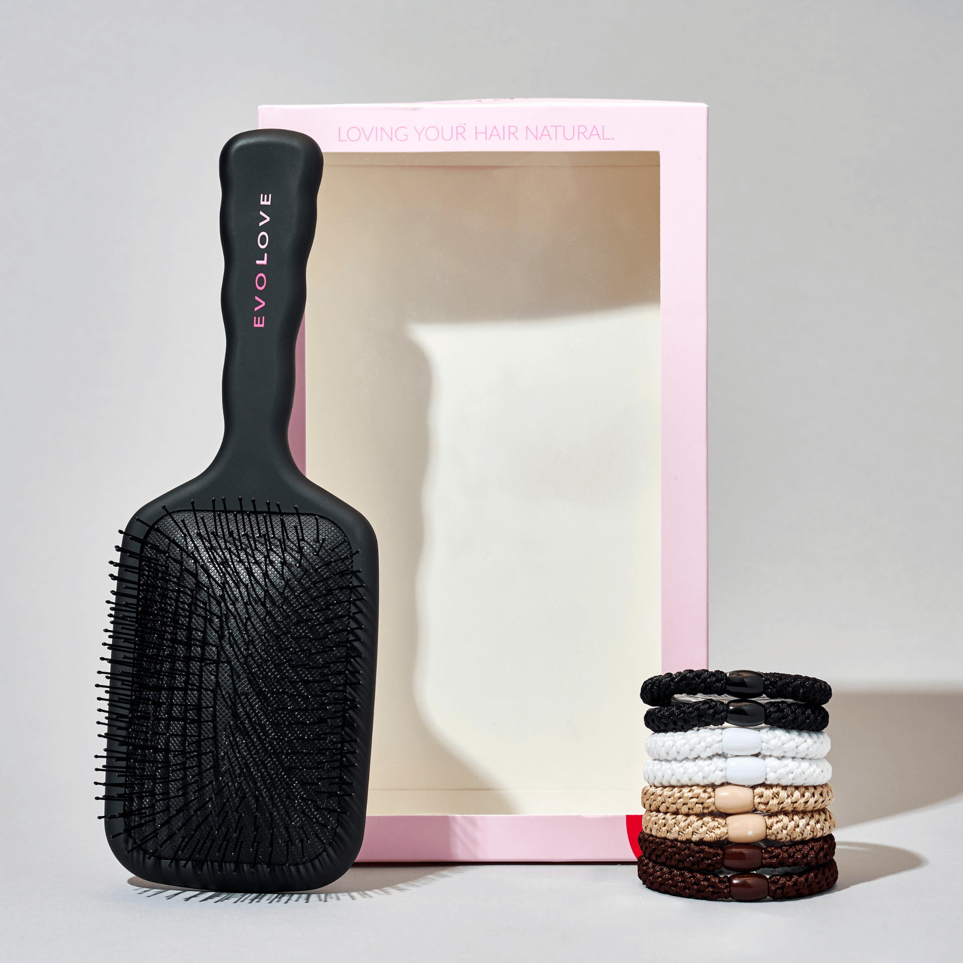 Hair brush and hair tie set displayed neatly next to each other.
