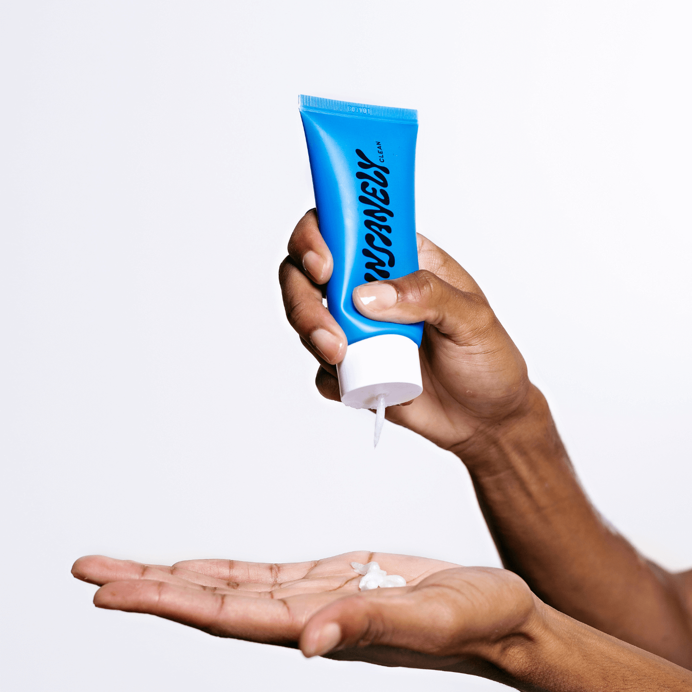 The best men's skincare product dripping out of the bottle onto a man's hand.