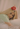 Female celebrity, Hayley Kiyoko, lying down holding her best-selling perfume.